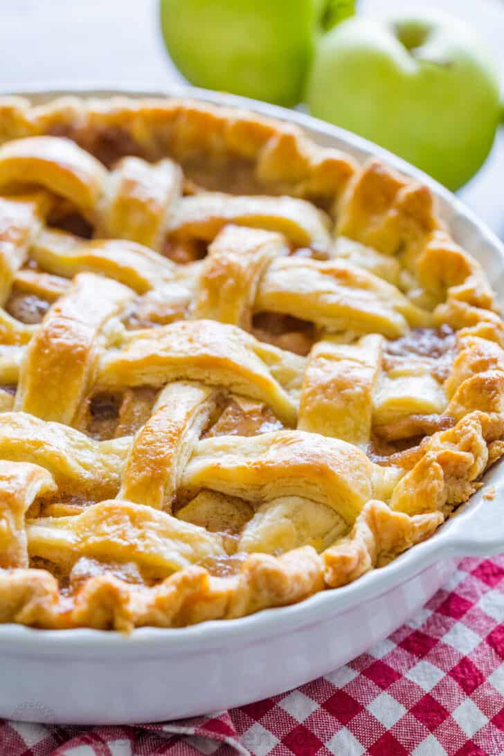 Apple pie prepared in a bowl along with green apple beside