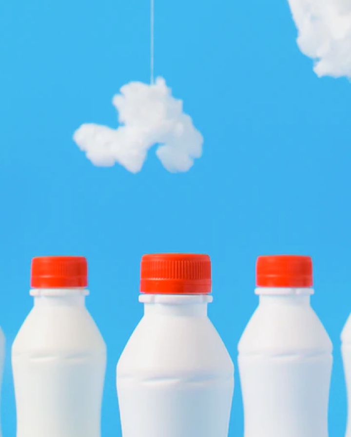 Portrait of milk bottles with sky as background